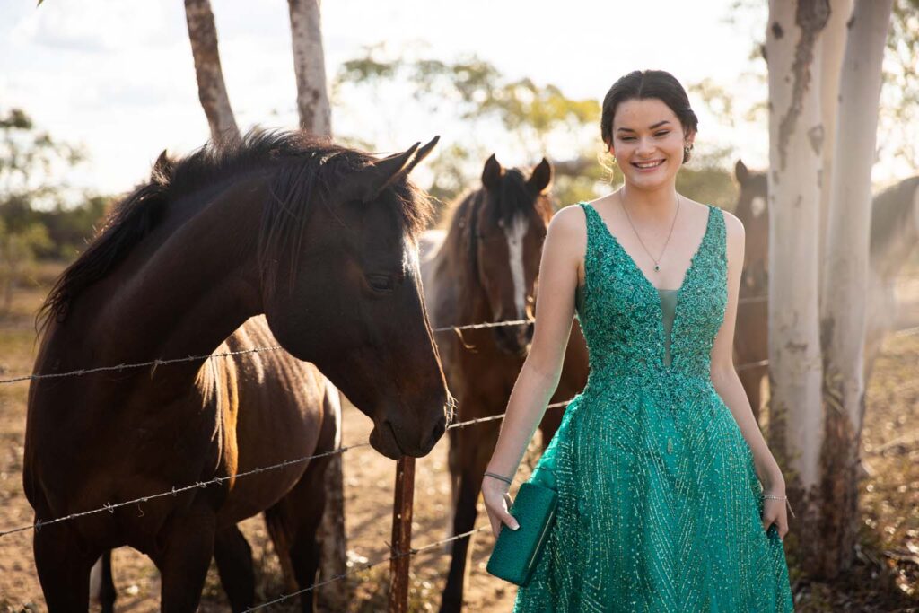 Young woman in formal clothes walking beside horse