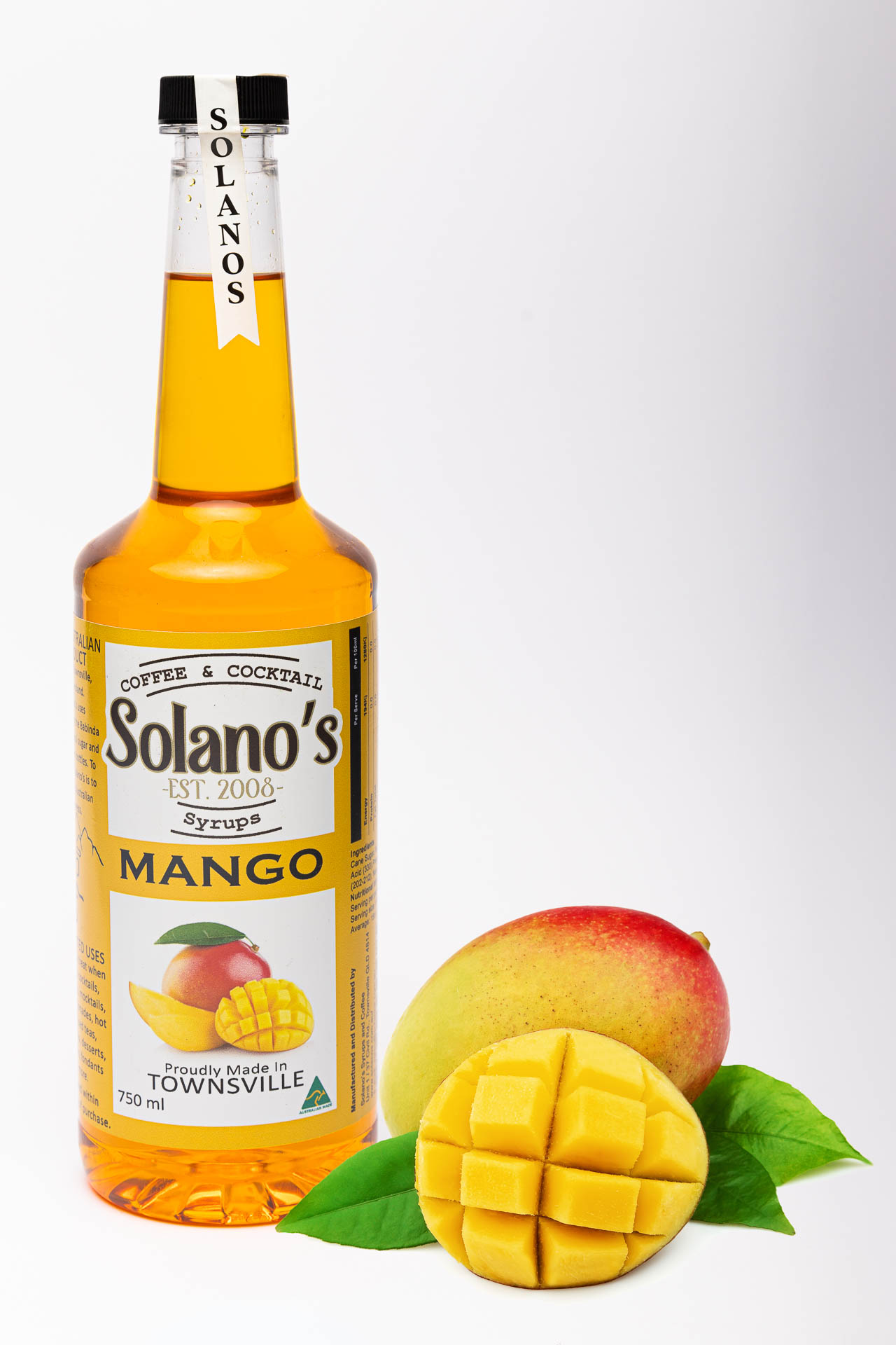product photography of mango coffee syrup with mangoes
